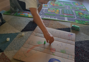 Julek gra w stworzoną przez siebie grę planszową „Wyścig do wodopoju”.